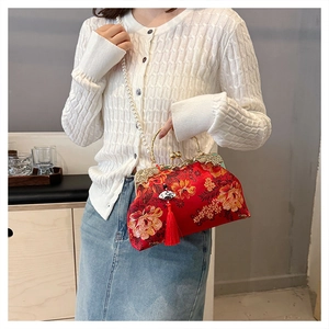 Détail d'un sac à main rouge style chinois avec broderie florale et chaîne de perles