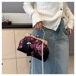 Vue détaillée de la broderie florale sur un sac en satin vintage avec perles