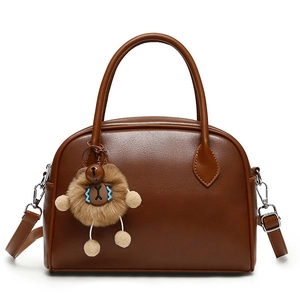 Brown faux leather crossbody handbag with rounded handles and a cute plush bear charm