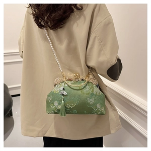 Détail de la broderie florale sur sac vert avec bandoulière perles et gland