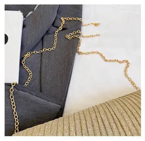 Detail of a gold pleated envelope clutch showing the textured metallic finish and chain