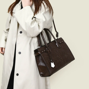 Detail showing deep brown crocodile texture leather bag with silver metal hardware accents