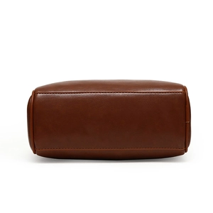 Detailed view of the dark brown PU leather handbag bottom with reinforced stitching