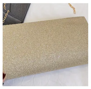 Detailed close-up of a sparkling gold sequin evening clutch with a sleek metallic chain