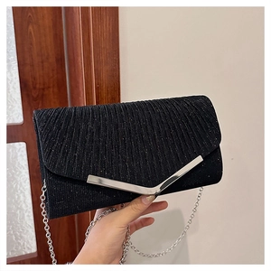 Close-up of black envelope clutch bag featuring pleated glitter fabric and V-shaped silver buckle