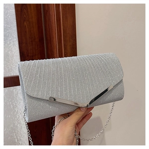 Detail of silver sequin envelope clutch with V-shaped metal trim and chain strap