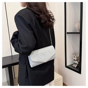 Detail of silver pleated envelope clutch with metal V-frame and delicate chain strap
