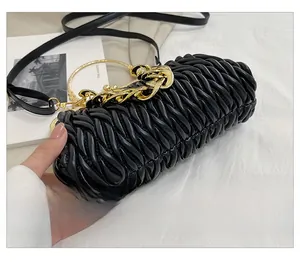 Detailed view of black pleated texture bag featuring a chunky gold chain strap and ring handle