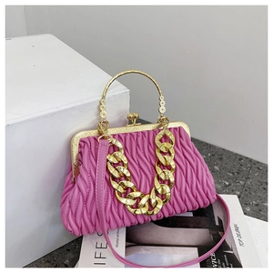 Détail du sac plissé rose fuchsia avec chaîne dorée et poignée ronde en métal