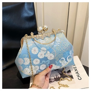 Dettaglio borsa a conchiglia in jacquard floreale azzurro con chiusura a perla e catena