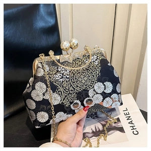Dettaglio borsa a mano vintage ricamata con fiori e chiusura con doppia perla