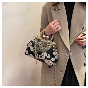 Dettaglio ricamo floreale e chiusura con perle su borsa a conchiglia vintage