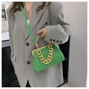 Detail of bright green pleated shell bag with gold kiss-lock and chain strap
