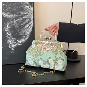 Dettaglio della borsa ricamata a fiori con chiusura a perla e catena d'oro