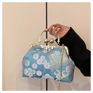 Dettaglio del ricamo floreale blu e del manico in metallo dorato della borsa vintage