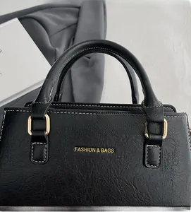 Detailed macro view of black lychee grain leather handbag with gold D-ring hardware