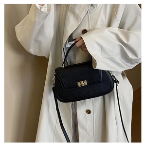 Vue détaillée du sac à main en cuir grainé noir avec fermoir géométrique doré chic