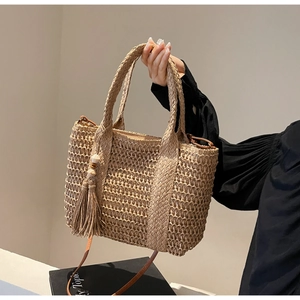 Fashionable beige straw woven tote bag with tassels and shoulder strap for vacation