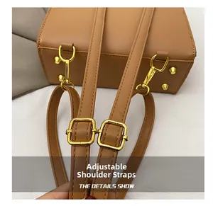 Détail du sac en cuir marron avec bandoulière réglable et rivets de protection dorés