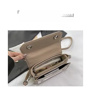 Interior detail of a multi-layer beige square bag showing spacious compartments