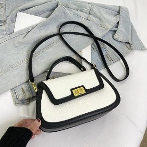 Sac à bandoulière beige chic avec bordure noire et fermoir doré de style rétro