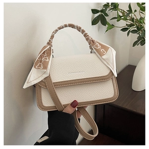 Detail of lychee pattern leather handbag with contrast trim and silk scarf handle