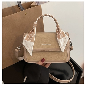 Detail of lychee pattern leather crossbody bag with silk scarf wrapped handle