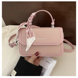 Detail of pink pebbled leather small square bag with silk scarf handle and silver metal buckle