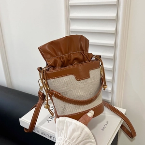 Brown leather and beige canvas bucket bag with drawstring closure for daily fashion
