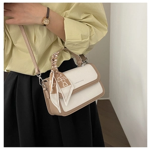 Detail of crossbody bag with litchi texture leather and decorative floral silk scarf