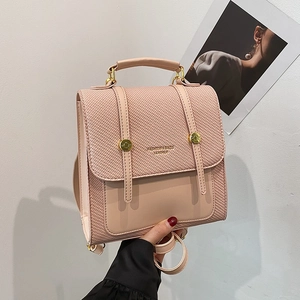 Sac à dos rose en cuir tressé pour femme avec boucle dorée et poignée en vue rapprochée