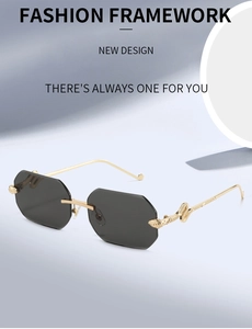 Detail view of gold metal temples with intricate snake relief on rimless sunglasses