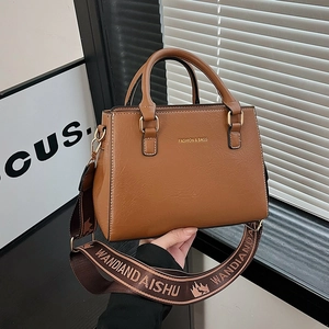 Brown faux leather tote bag with wide textile strap and gold-tone hardware for women