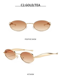 Detail view of oval metal sunglasses with golden wavy temples and tea gradient lenses