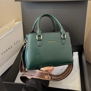 Minimalist dark green leather tote bag with gold lettering and wide designer strap