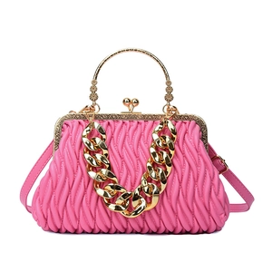 Pink Matelassé shell handbag with gold metal handle and chunky chain strap on white background