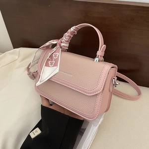 Pink crossbody bag with silk scarf handle and FASHION & BAGS print in lifestyle setting
