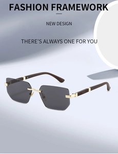 Detail view of rimless hexagonal sunglasses with gold metal bridge and dark grey lenses