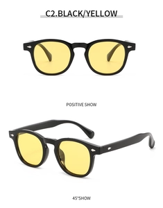 Close-up of retro round black frame sunglasses with yellow lenses and silver rivets