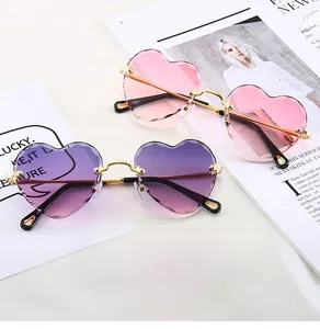 Detail of rimless heart sunglasses with gradient pink and purple lenses and gold arms