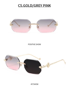 Detail of rimless polygon sunglasses with gold snake temple design and grey pink lenses
