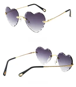 Detail view of heart-shaped rimless sunglasses with purple gradient lenses and gold metal arms