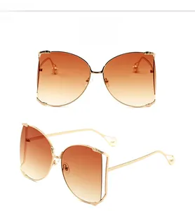 Vue macro de lunettes papillon oversize dorées avec verres dégradés marron et perles décoratives