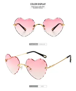 Detail of pink gradient heart-shaped rimless sunglasses with gold metal cut-edge lenses