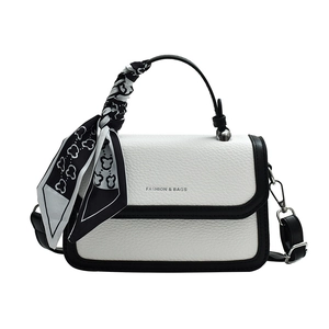 White pebbled leather crossbody bag with black trim and elegant silk scarf handle