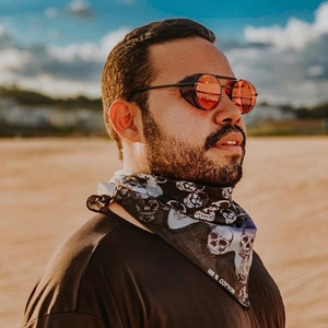 Dettaglio occhiali steampunk rossi con ripari laterali e bandana nera con teschi