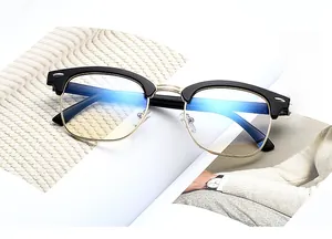 Detailed view of semi-rimless glasses with black and gold frames on a white background