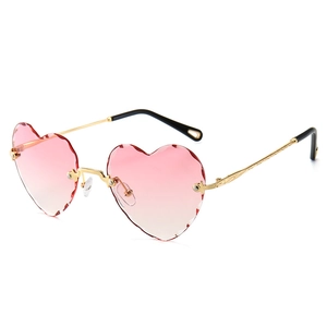Frameless heart shaped sunglasses with pink gradient cut edge lenses and golden temples
