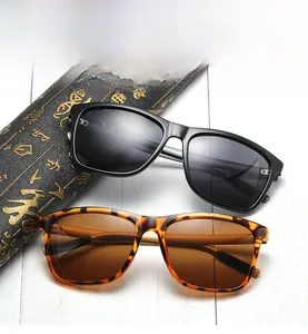 Polarized square sunglasses in black and tortoise shell frames on white wood