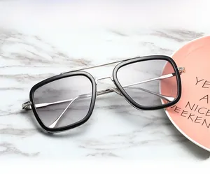 Detail of square pilot sunglasses with black and gold frame on marble texture